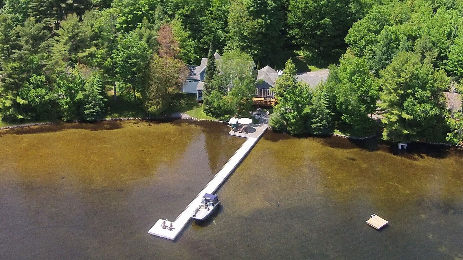 Aerial view of Baypoint cottage and its private dock extending into Lake Joseph.