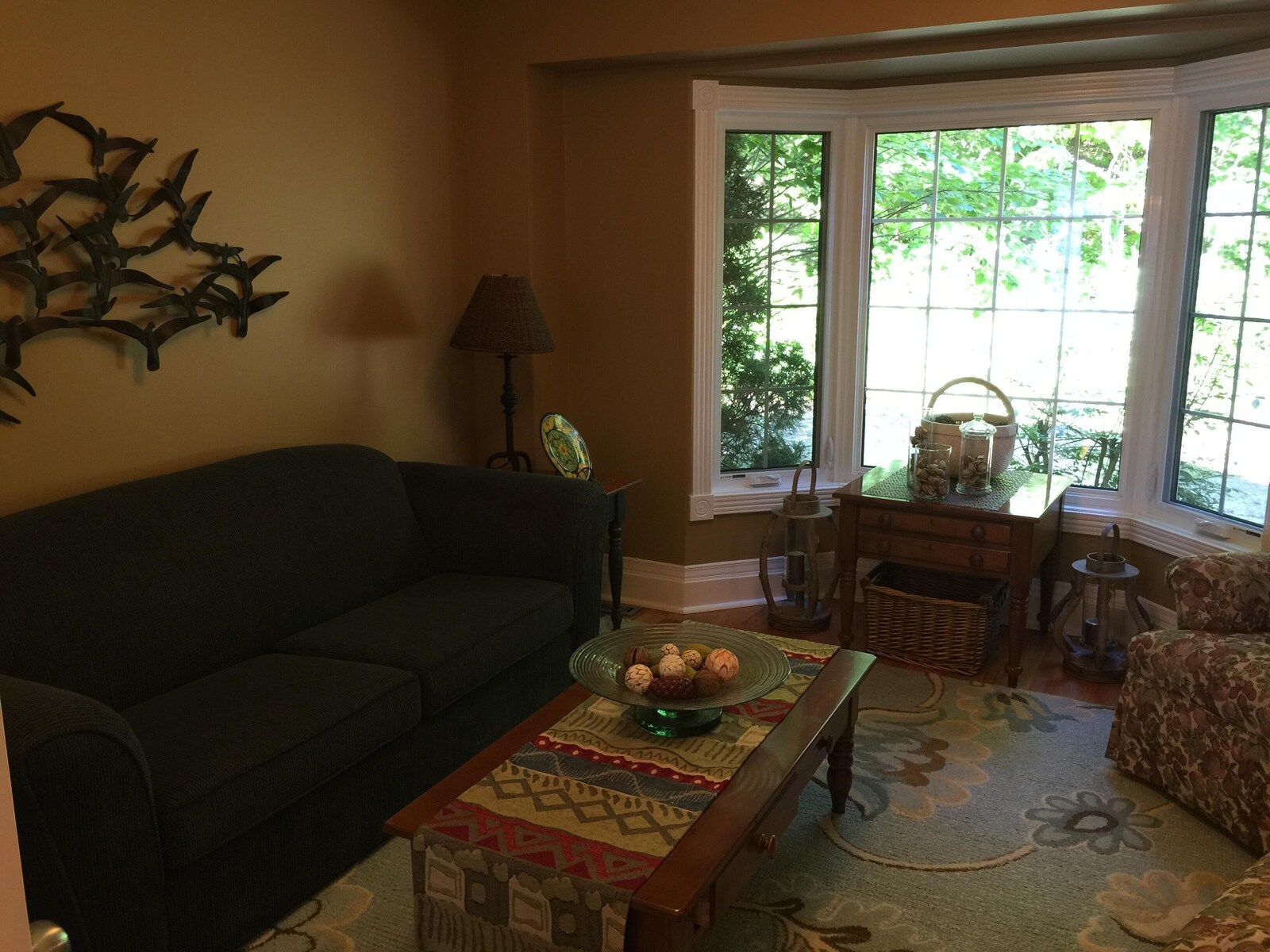 Private den with sofa and bay window.